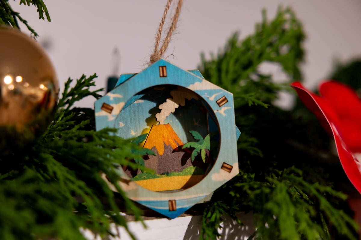 Decorative 3D ornament with a tropical scene hanging on a Christmas tree.