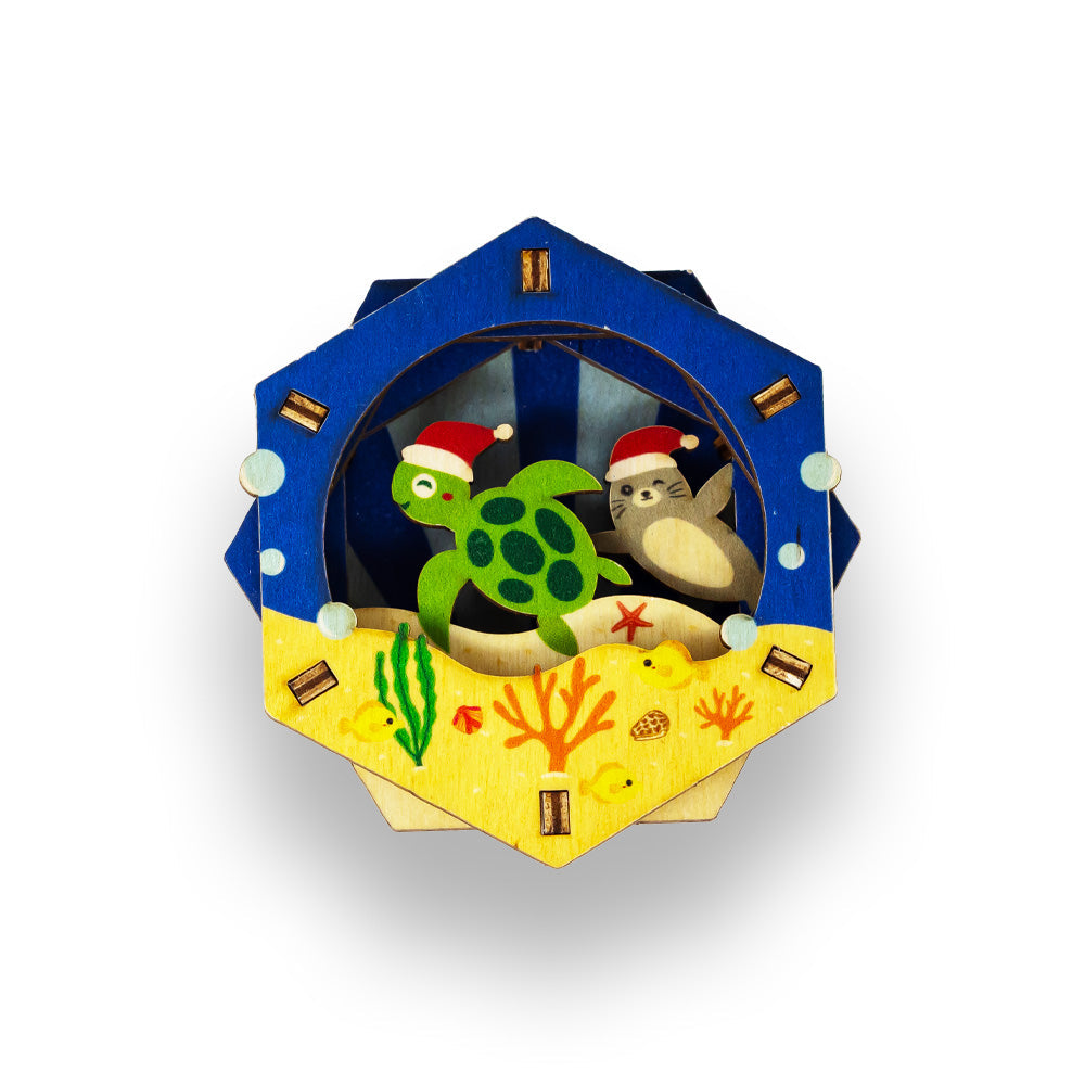 Decorative 3D ornament with a turtle and monk seal in Santa hats on an underwater-themed background