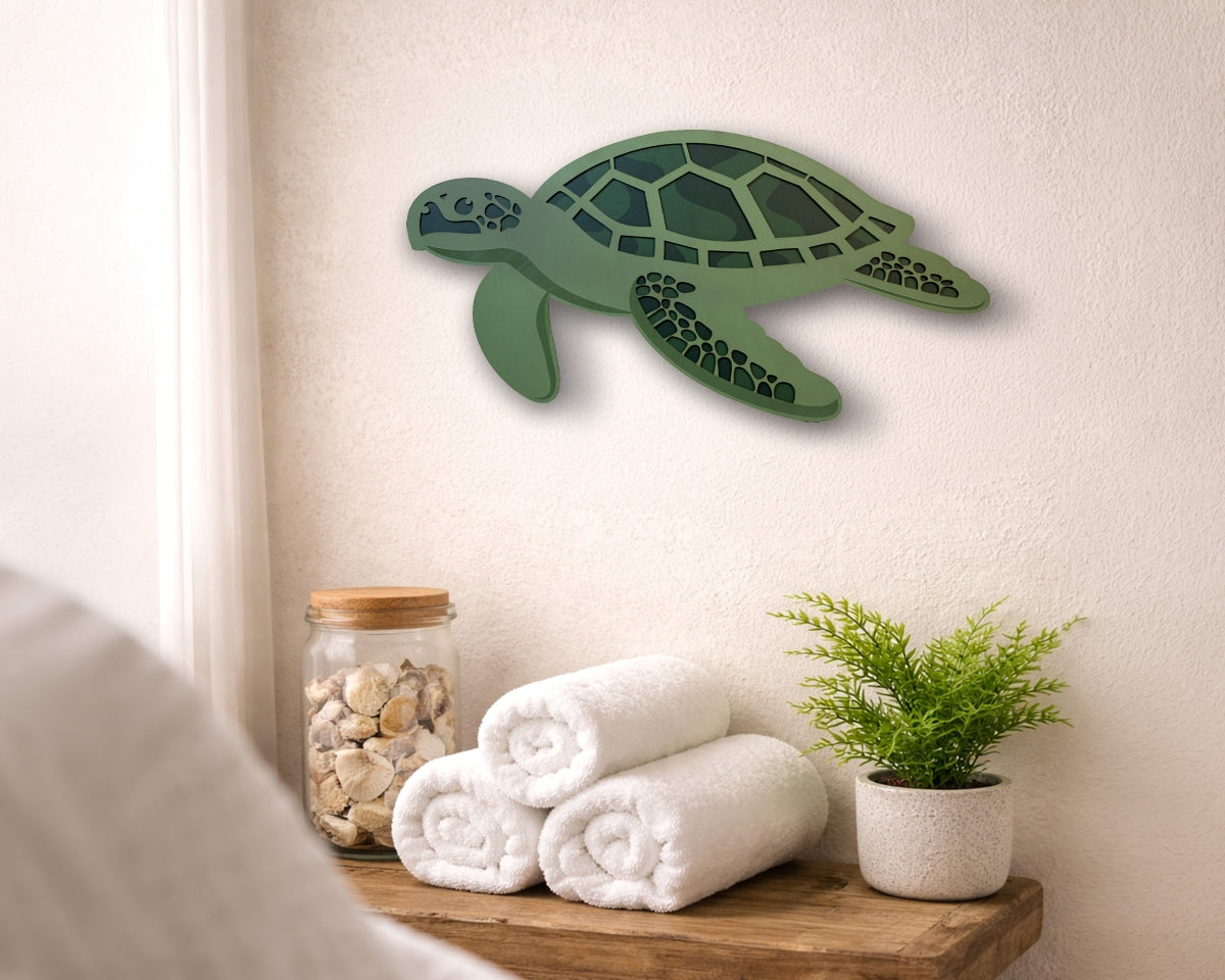 Green turtle layered wall decoration on a neutral wall with towels and a plant below.