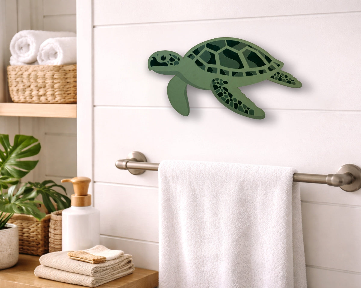 Green turtle wall decor in a bathroom setting with towels and plants.