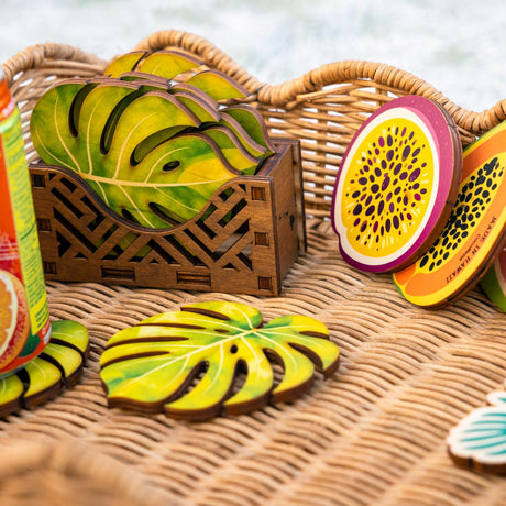 Fruit-themed coasters on a woven surface with a wooden crate.