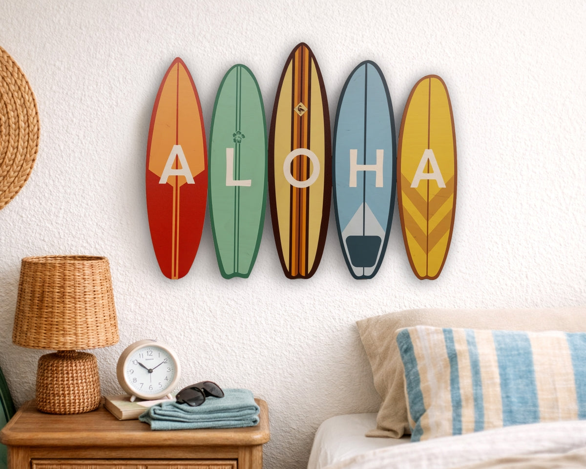 Five colorful surfboard-shaped signs spelling 'ALOHA' on a wall above a bed.
