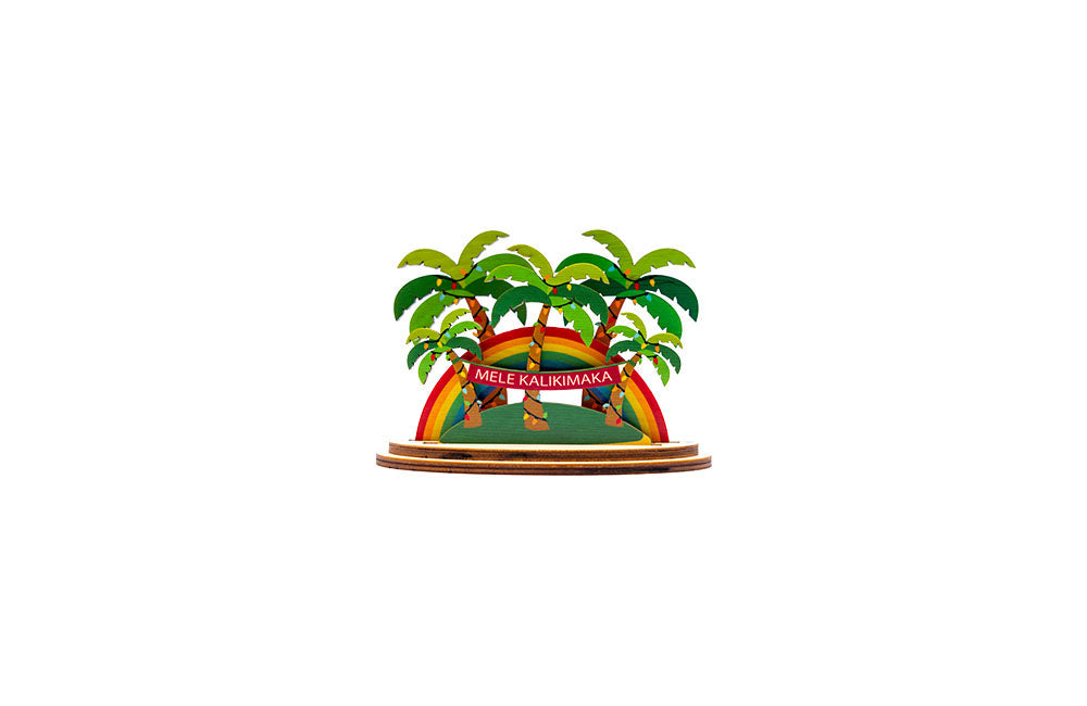 3D decorative sign with grove of Christmas palm trees, rainbow, and Mele Kalikimaka text on a white background