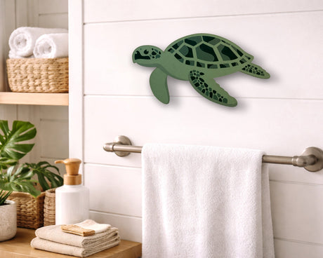 Green turtle wall decor in a bathroom setting with towels and plants.