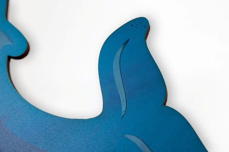 Close up detail of blue whale tail wood wall decor on a white background